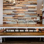 dining room with table, benches, chairs, reclaimed wood wall